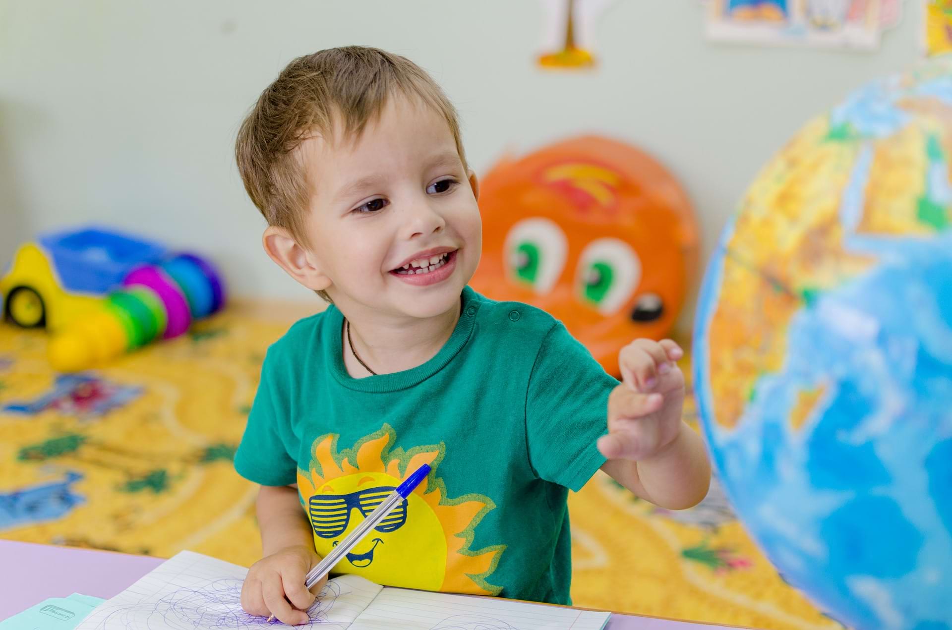 Enfant souriant en train de dessiner 