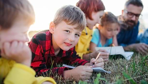 Jeunes enfants prenant des notes sur le paysage en classe de découverte