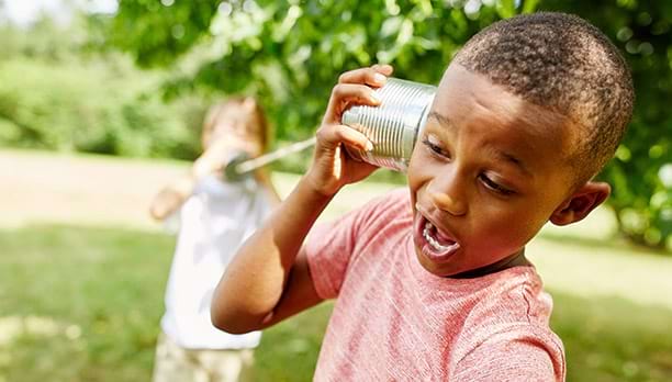 Jeune garçon utilisant un téléphone à corde