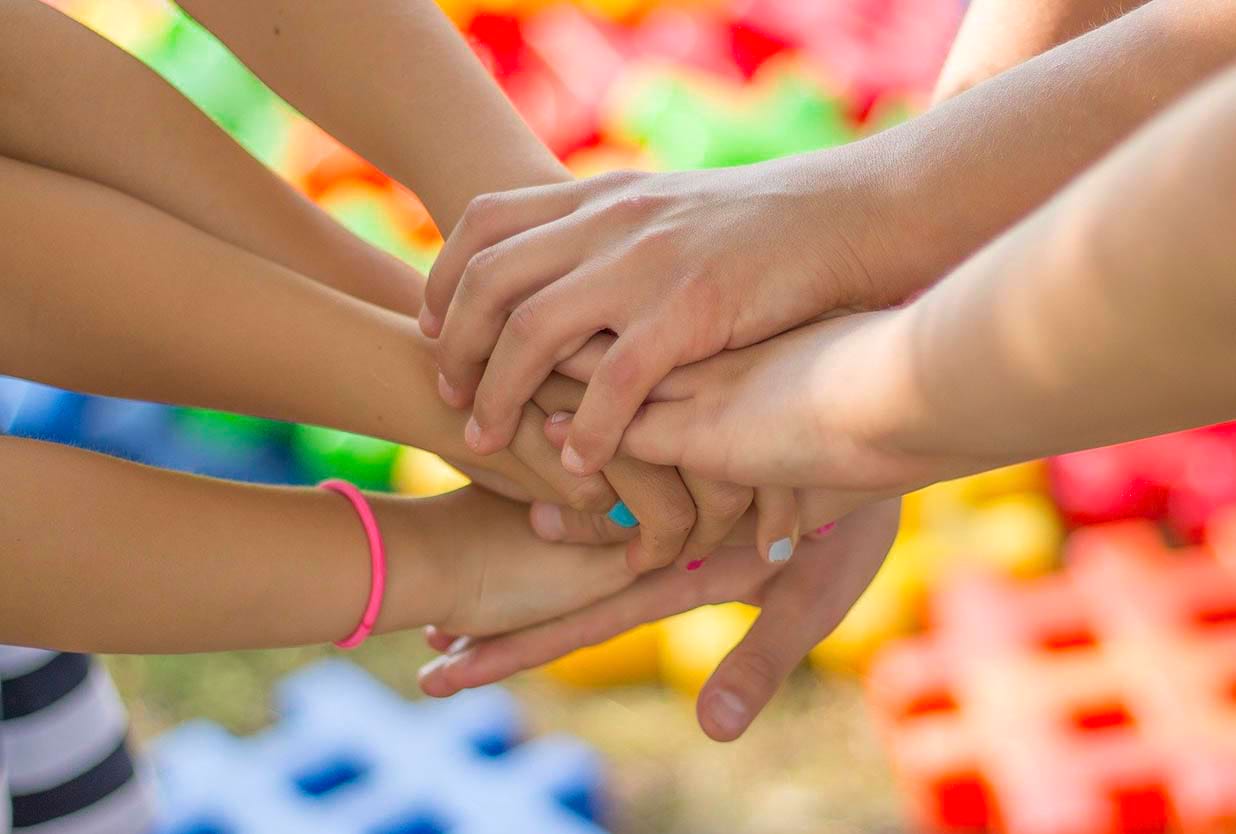 Groupe d'enfants unissant leurs mains en classe de découverte