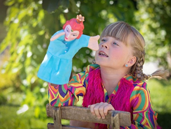 Une petite fille tient une marionnette à la main