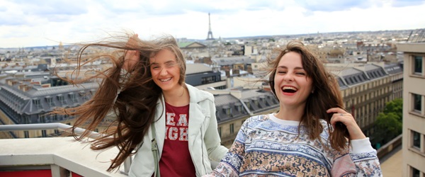 Deux jeunes filles souriantes avec la Tour Eiffel en fond