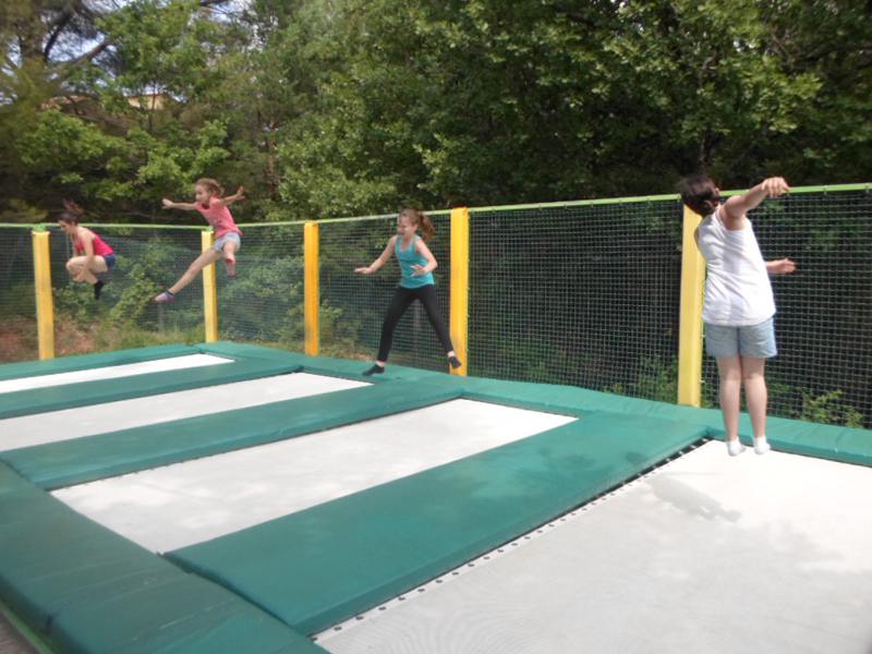 groupe d'enfants faisant du trampoline en colonie de vacances d'été