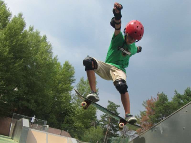 pré adolescent faisant du skateboard en colonie de vacances d'été