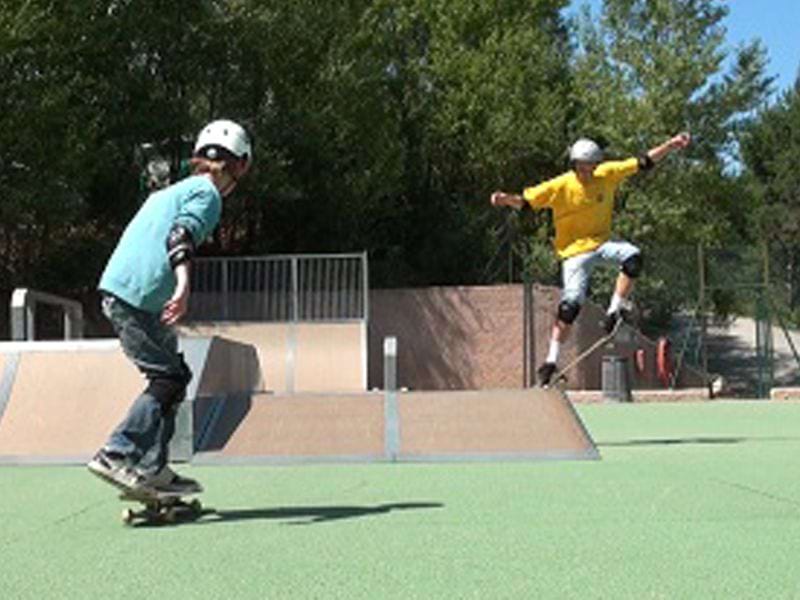 Adolescents faisant du skate et de la trottinette en colonie de vacances d'été