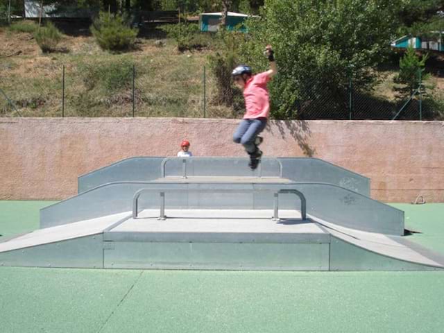 Enfant faisant des sauts en roller au skatepark de colonie de vacances cet été