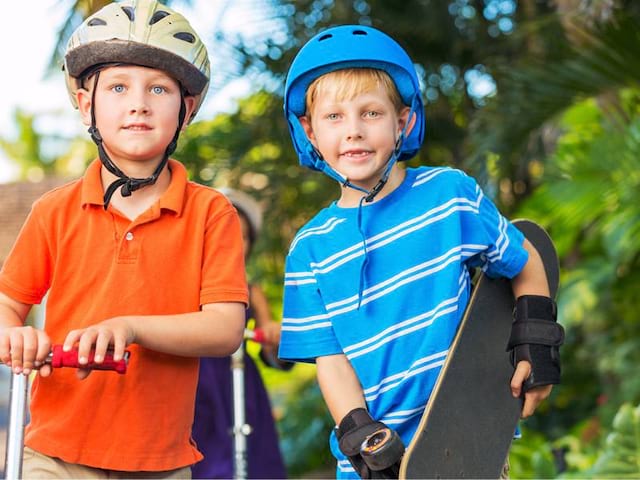 Portrait de deux enfants avec leur skate et leur trottinette en colonie de vacances d'été