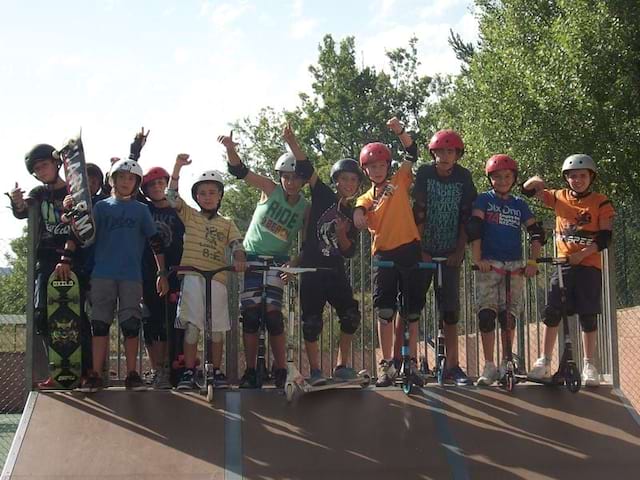 groupe d'enfants apprenant à faire du skatebaord et des roller en colo