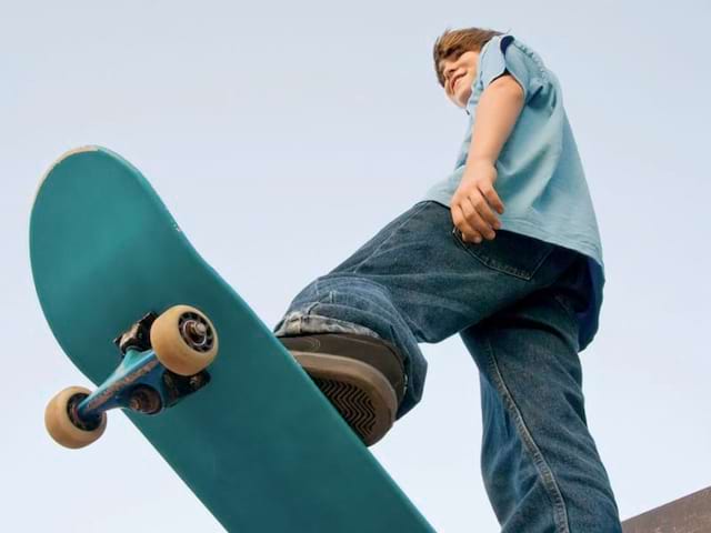 Enfant pratiquant le skateboard à haut niveau en colonie de vacances