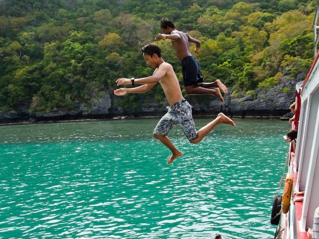 Deux ados sautant dans l'eau en colonie de vacances