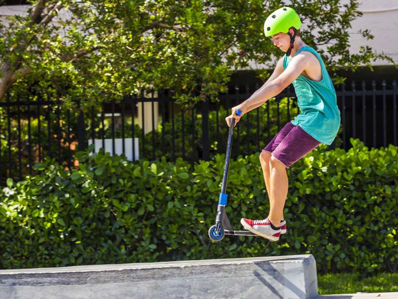 Enfant pratiquant le saut à trottinette en colonie de vacances multiactivités