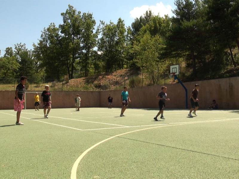 Ados jouant au football en colonie de vacances d'été multiactivités