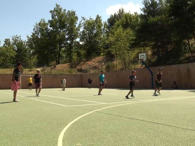 Groupe d'enfants sur un terrain de sports en colonie de vacances