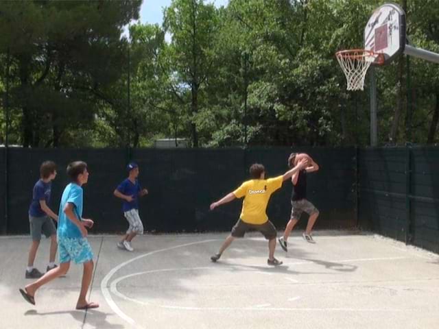 enfants jouant au basketball en colonie de vacances d'été