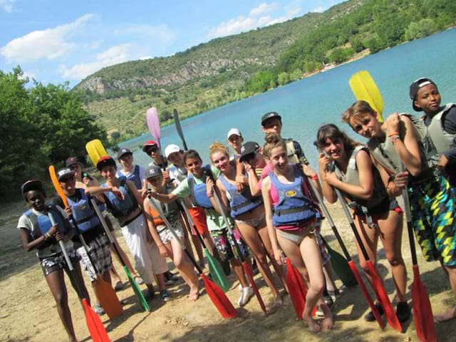 Groupe d'enfants en colo s'appretant à faire du canoe kayak