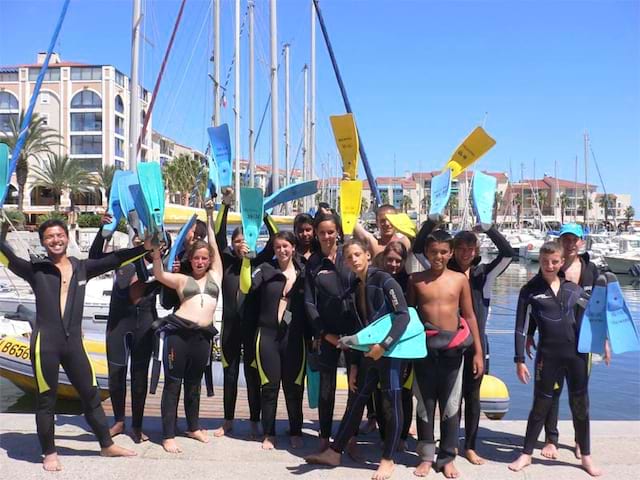 Groupe d'adolescents et leur moniteur en tenue de plongée sous marine en colonie de vacances