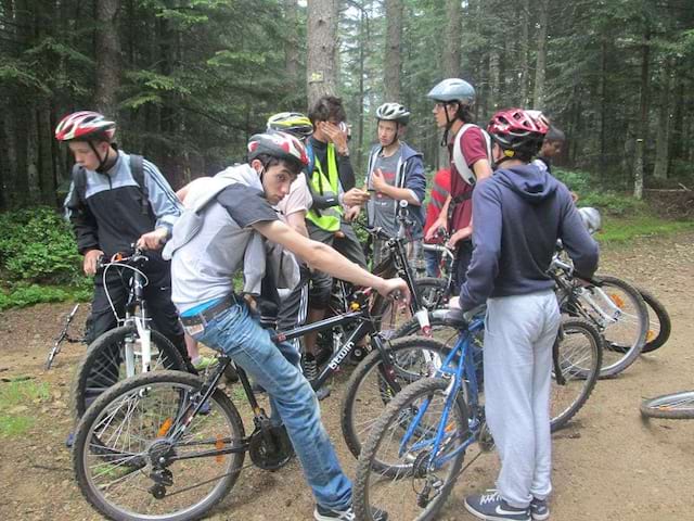 Groupe d'ados en colonie de vacances en balade à vélo