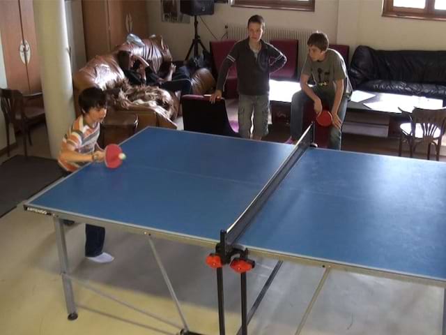 Enfants jouant au tennis de table en colonie 