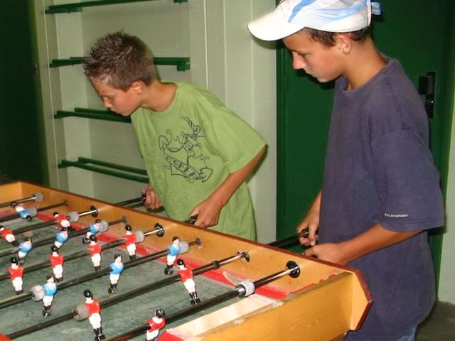 Enfants jouant au baby foot en colo