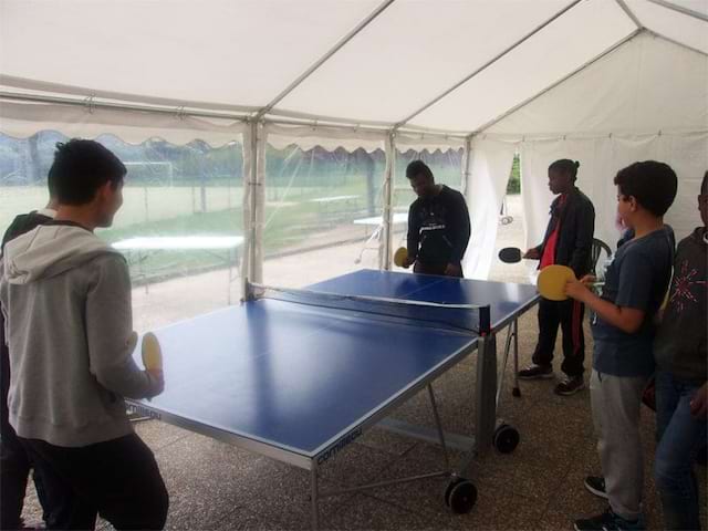 Enfants et ados jouant au ping pong en colonie de vacances d'été