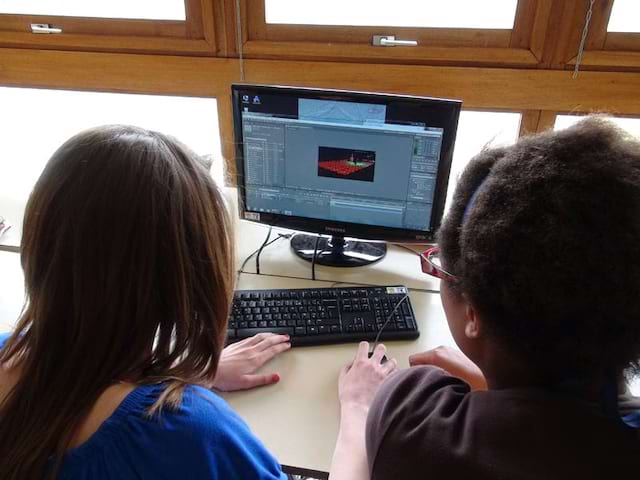 Deux jeunes filles apprenant à faire du montage vidéo en colonie de vacances cinéma été