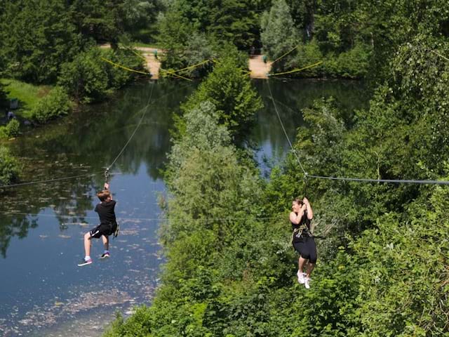 Deux ados faisant de la tyrolienne en colo à la montagne cet été 