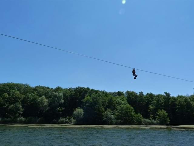 Adolescent faisant de la tyrolienne en colonie de vacances été à la montagne