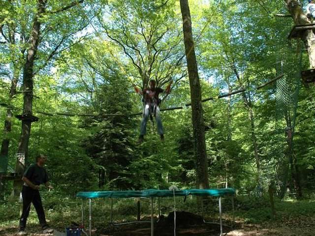 Adolescent faisant du trampoline en colo été à la montagne