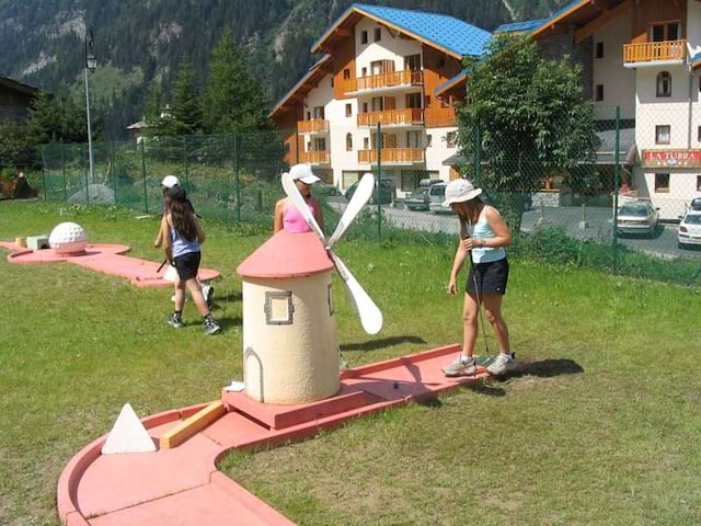 Enfants jouant au mini golf en colonie de vacances à la montagne