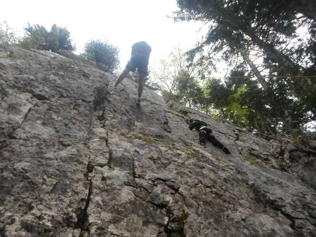 Ado pratiquant la descente en rappel sur voies naturelles en colonie de vacances escalade