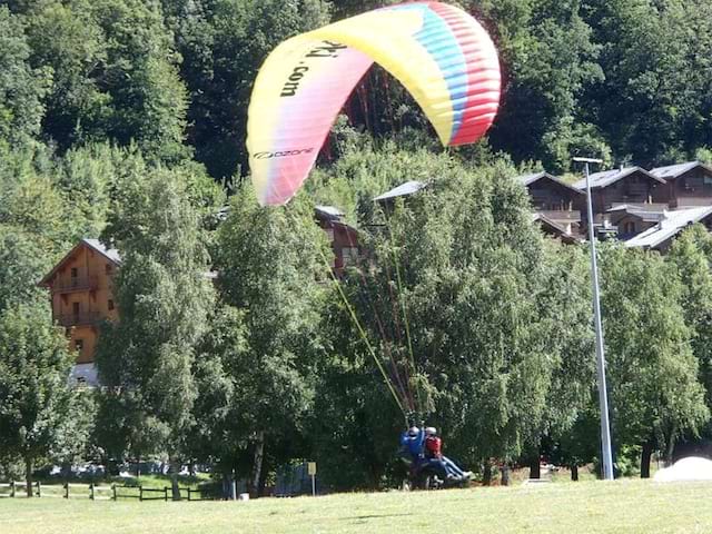 Enfant en plein atterrissage de parapente aux Saisies