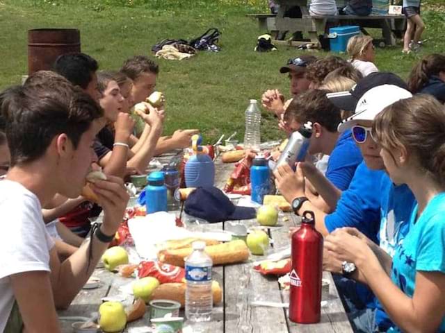 Adolescents et enfants faisant un pic nic en colo aux Saisies