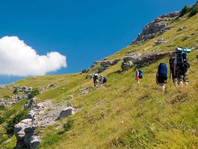 Adolescents et enfants en randonnée à la montagne