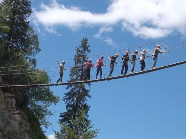 Groupe d'enfants faisant de la via ferrata en colonie de vacances