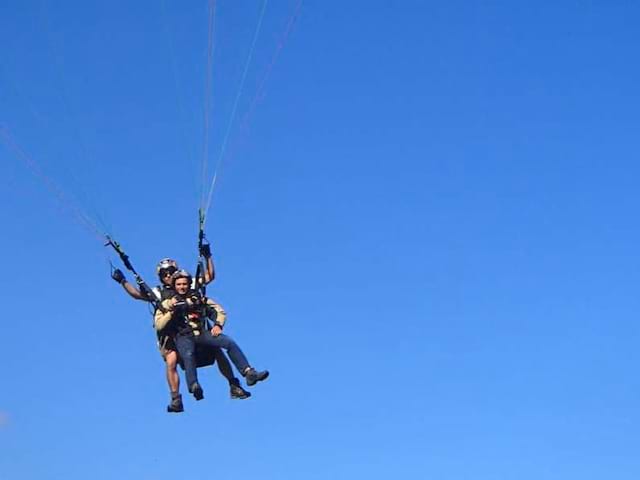 Enfant dans les airs faisant du parapente à Courchevel à la montagne cet été