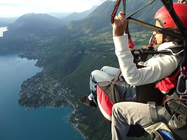 Enfant dans les airs en parapente en colonie de vacances à la montagne