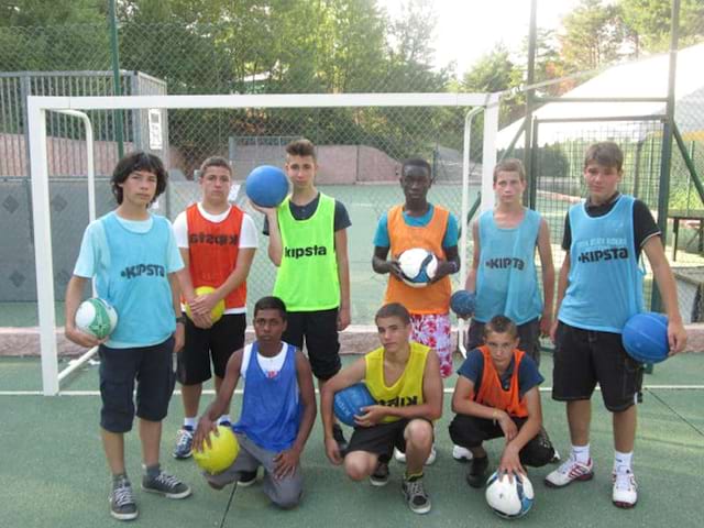 Groupe d'enfants et ados jouant au football en colonie de vacances