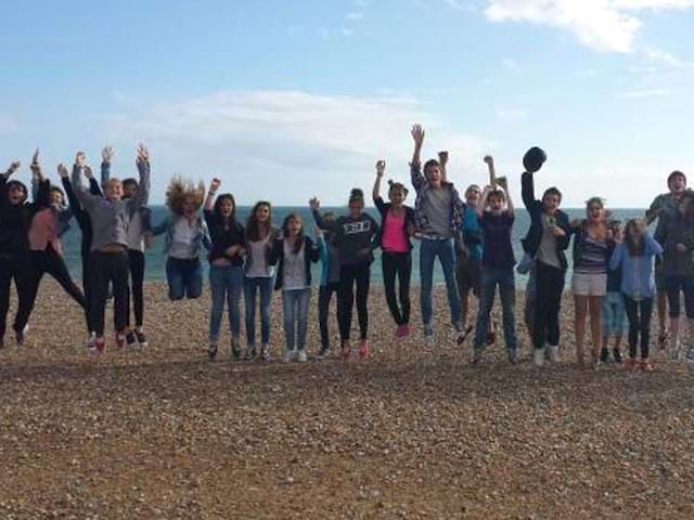 Groupe d'adolescent qui saute sur les plages de Brighton en Angleterre en été