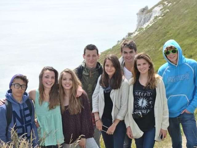 Un groupe d'adolescent devant les falaises du cap Béveziers en Angleterre