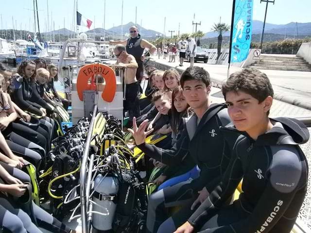 groupe d'adolescents en tenue de plongée sous marine pour le baptême de plongée dans les iles en colonie de vacances