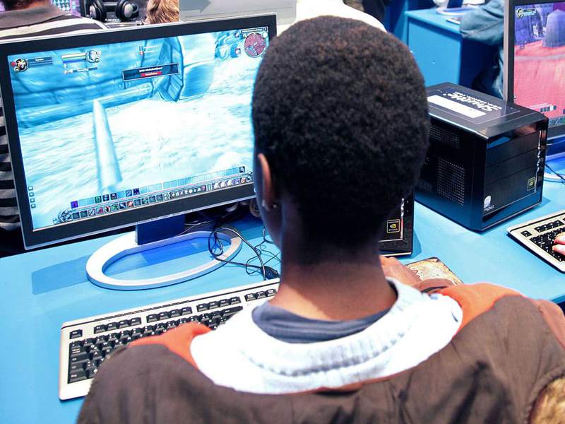 Adolescent jouant à un jeux vidéo en ligne en colonie de vacances d'été pour geek