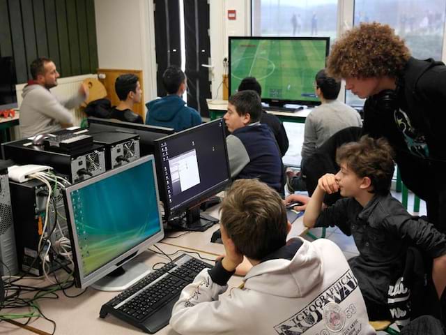 Enfants jouant aux jeux vidéos en colonie de vacances geek