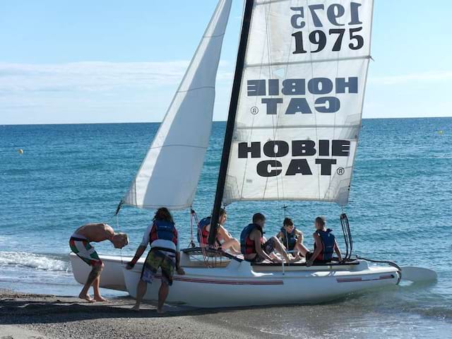 groupe d'ados sur un catamaran en bord de mer cet été durant un camp de vacances pour ados a la mer