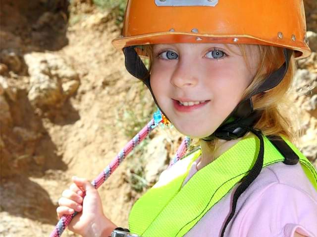 Portrait d'une jeune fille portant un casque pour l'escalade en colonie de vacances d'été