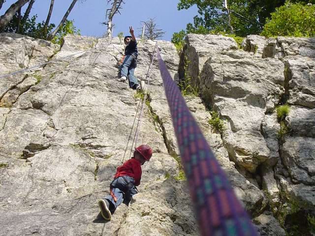 Enfants apprenant à faire de la descente en rappel en colo