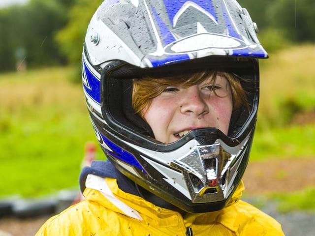 Portrait d'un enfant portant un casque de moto en colonie de vacances moto cross