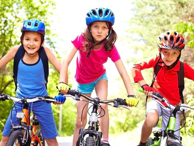 Trois enfants à vélo en colonie de vacances