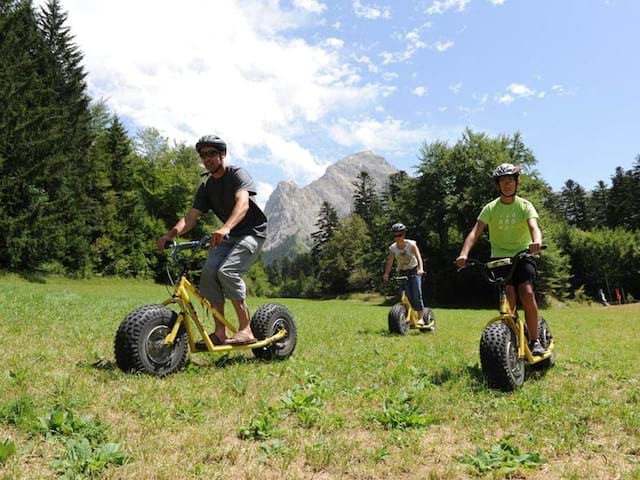 Groupe d'enfants sur des trottinettes tous terrains en colonie de vacances d'été