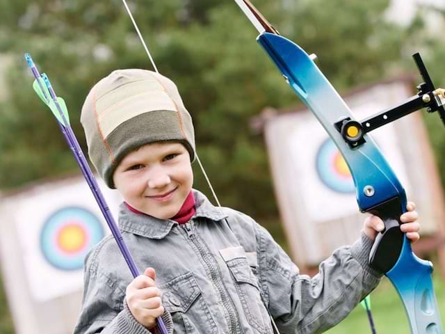 Jeune garçon avec son arc pour le tir à l'arc en colonie de vacances été