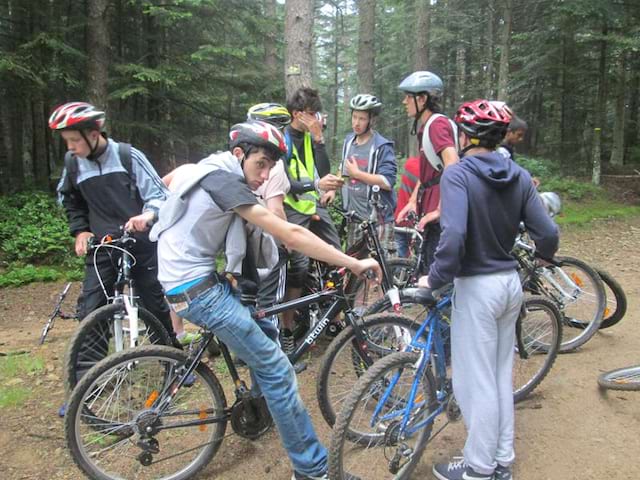 Adolescents en pleine forêt en randonnée à vélo en colonie de vacances été